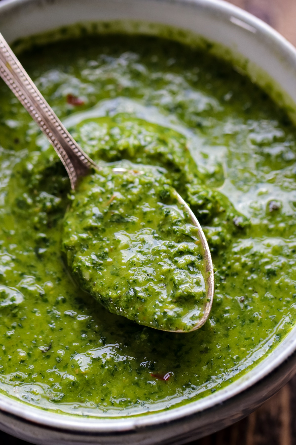Green harissa in a bowl with a spoon closeup