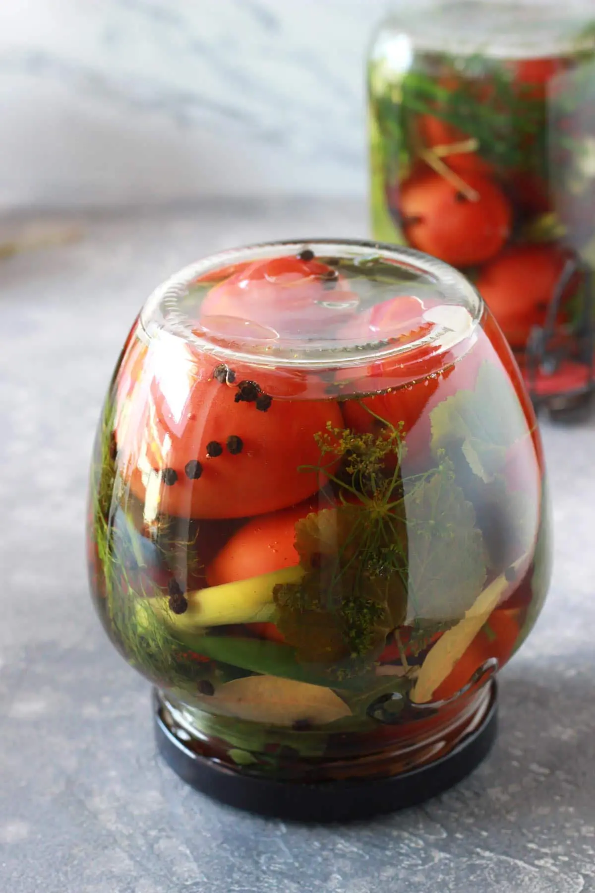 A jar with tomatoes upside down.