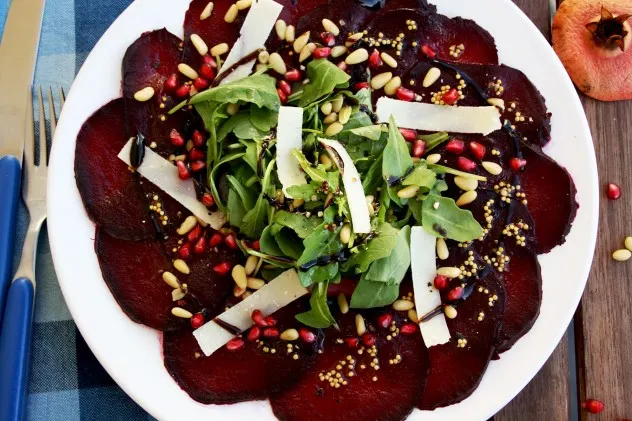 A beautiful, effortless, healthy and flavorful beetroot carpaccio with orange mustard vinaigrette and pomegranate seeds, served with parmesan and arugula.4