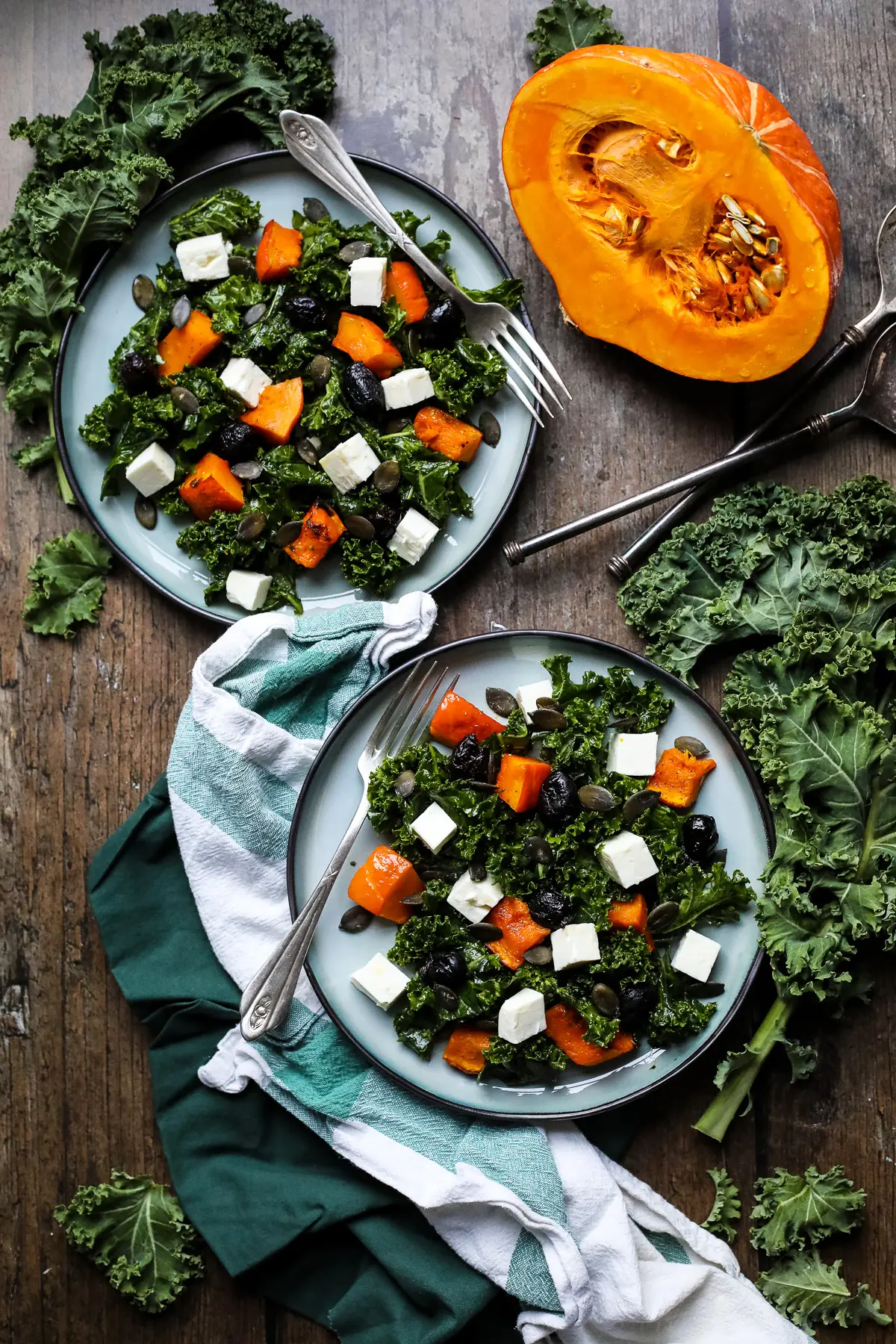 Plates with kale salad with pumpkin and feta.