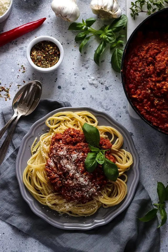 Vegan Spaghetti Bolognese on a Plate Next to Sauce