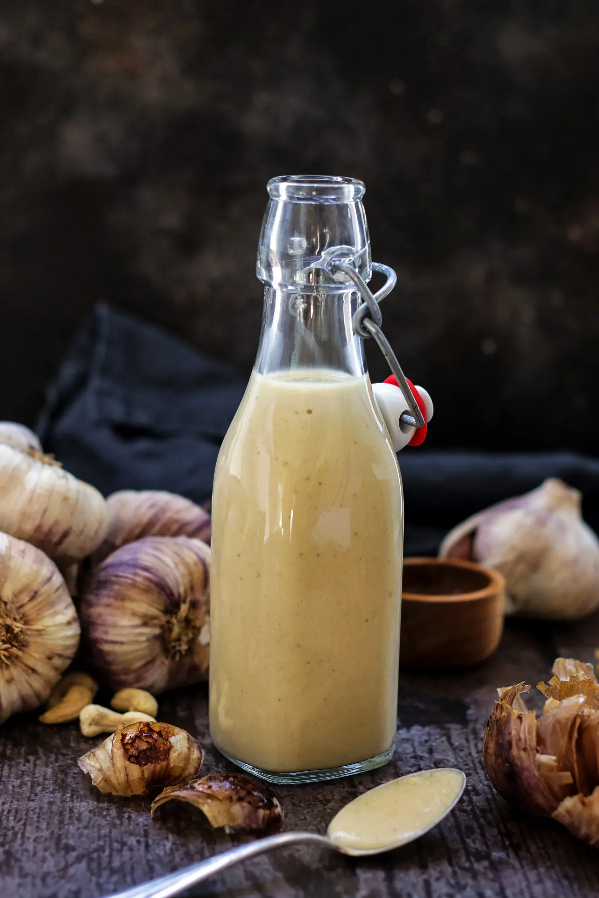 A bottle of roasted garlic dressing with a spoon.
