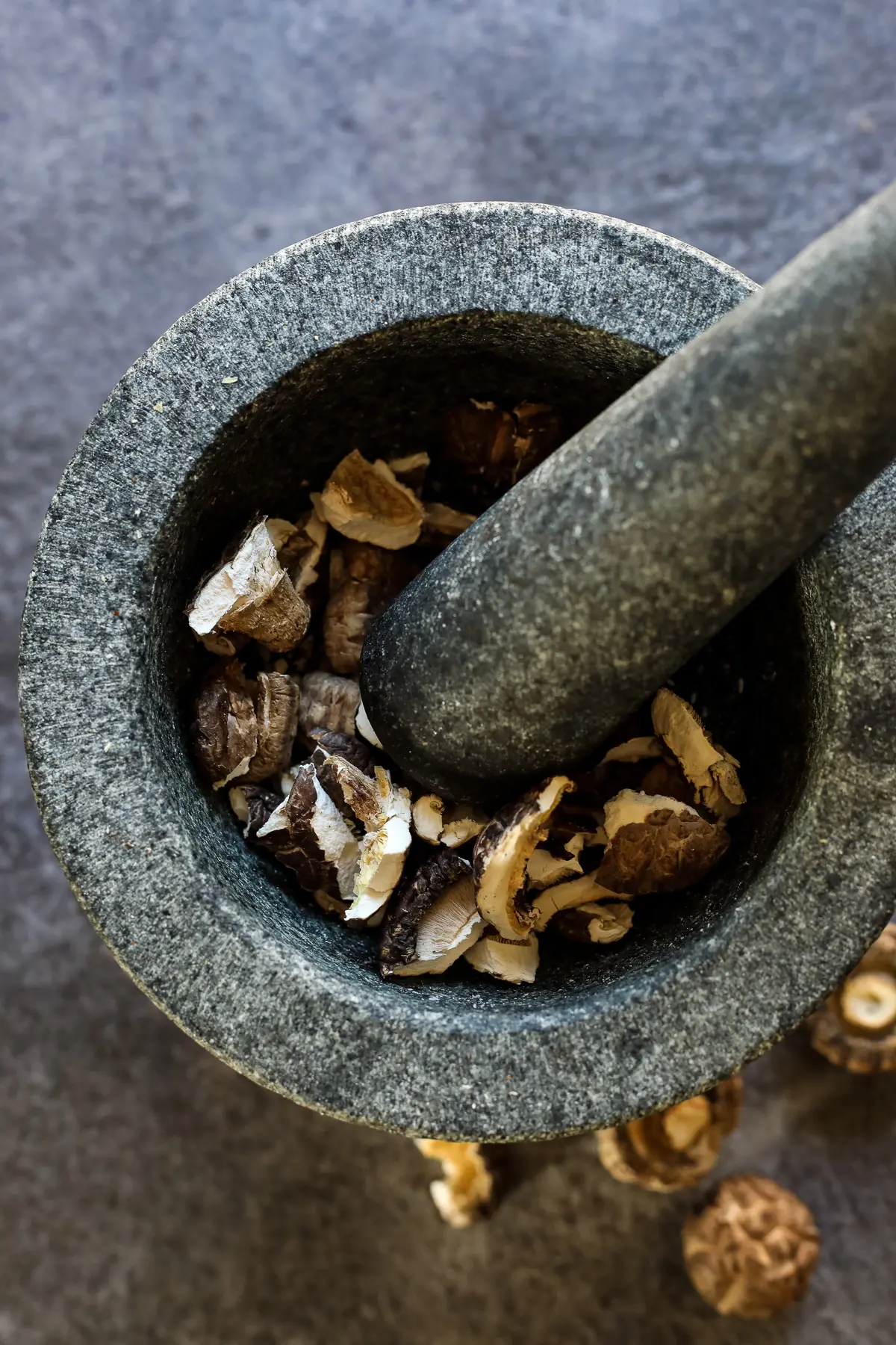 Breaking Dried Shiitake Mushrooms with a Mortar and Pestle.