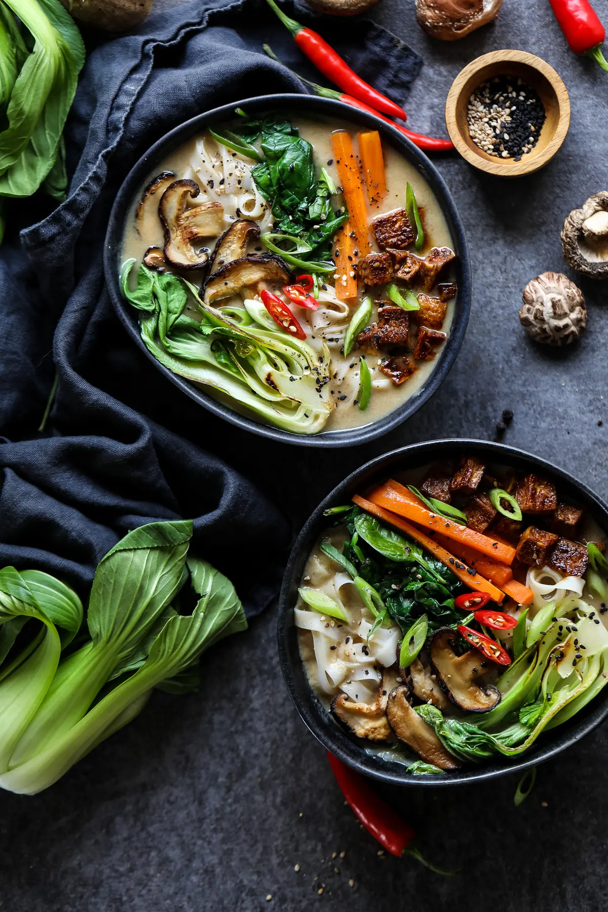 Two Vegan Ramen Bowls Surrounded by Ingredients.