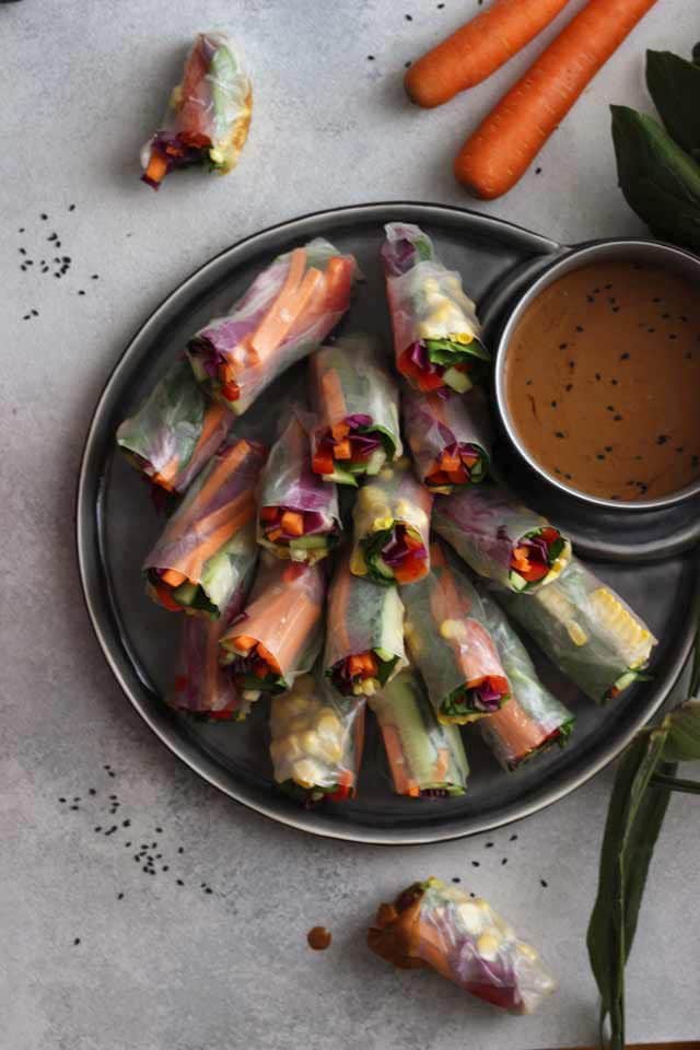 Fresh Vegan Spring Rolls Overhead with Sauce, Carrots and Seeds Around