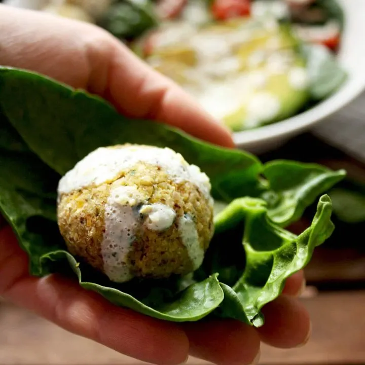 Crispy Baked Falafel with Hazelnuts and Creamy Lemon-Mint Sauce - Holding One in Hand