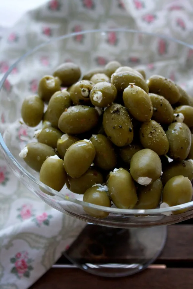 Cream Cheese Stuffed Olives in a Glass Bowl and a Cloth Near the Bowl