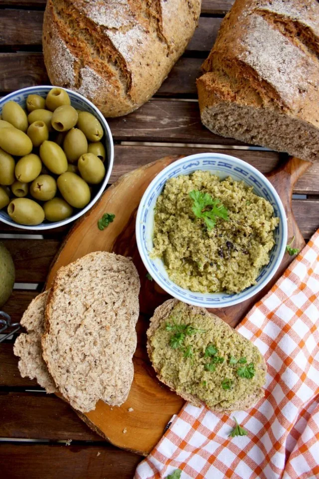 Olive Tapenade Dip with Some on the Bread Pieces, Shot from the Top