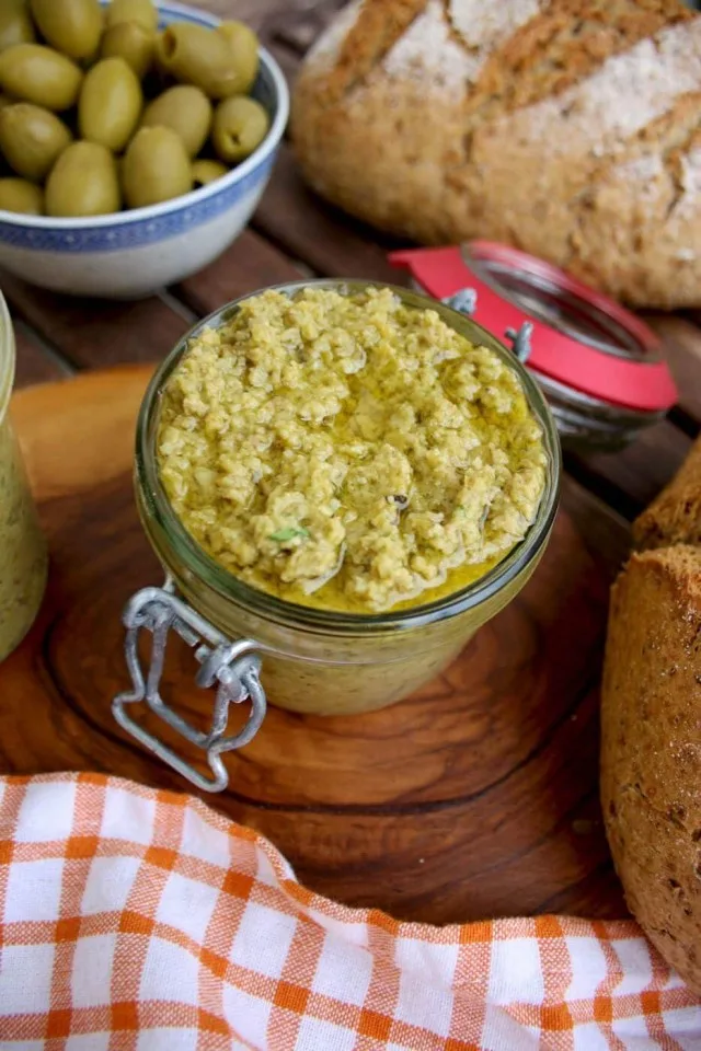 Olive Tapenade Dip with Bread and Olives around on the Table