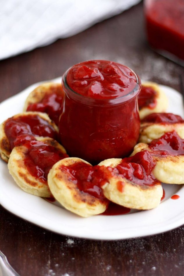 Russian syrniki are farmer's cheese pancakes, fluffy, pillowy and tender, topped with sweet strawberry vanilla sauce. My Russian mother's breakfast recipe.