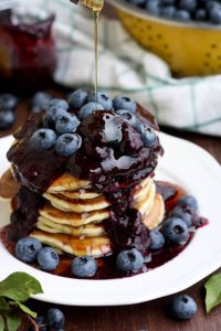Blueberry Ricotta Pancakes with Maple Syrup Poured Over the Pancakes