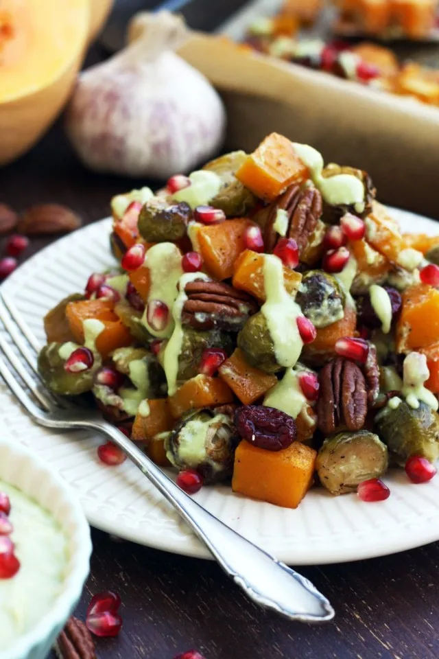 Balsamic-maple roasted Brussels sprouts with butternut squash garnished with pecans, cranberries and avocado roasted garlic dressing.