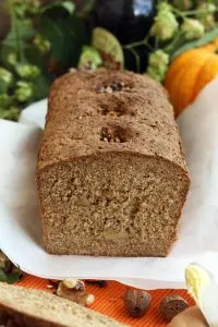 Healthy Pumpkin Bread with Walnuts on a White Paper Surrounded by Raw Ingredients