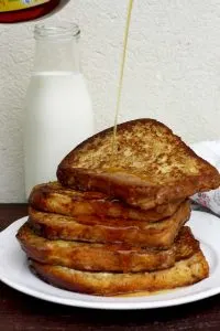 Healthier Brioche French Toast Pouring Syrup on Top with Milk in the Background