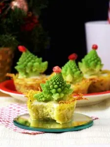 Christmas Tree Mini Quiches with One Quiche Bitten Once in the Foreground