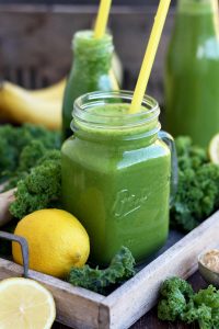 Delicious Kale Smoothie Closeup with Lemon and Greens Around