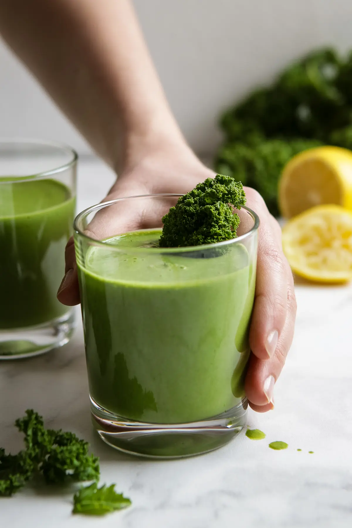 Hand Holding a Glass with Green Smoothie.