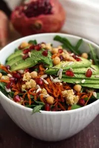 Healthy Sweet Potato Noodle Salad with Chickpeas and Rocket - Bowl Closeup with a Pomegranate in the Background