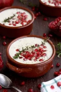 Cauliflower Soup Garnished with Thyme and Pomegranate Seeds in Bowls