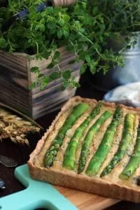 The Best Vegan Quiche Ever on a Wooden Tray with Wheat Next to It