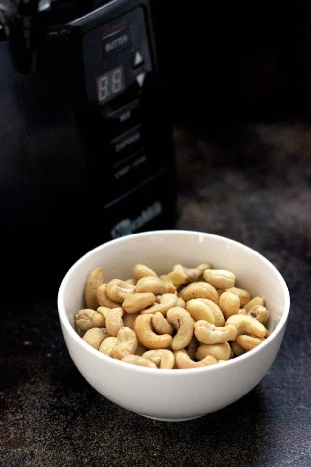 Healthy Vegan Pumpkin Spice Latte - The NutraMilk and a Bowl of Cashews on the Dark Table