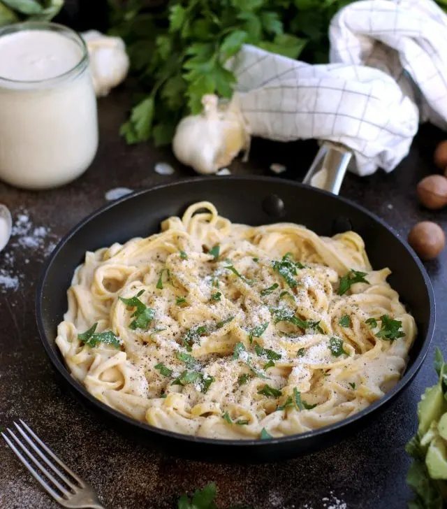 The Creamiest Vegan Fettuccine Alfredo - in a Skillet Garnished and Ready for Dinner