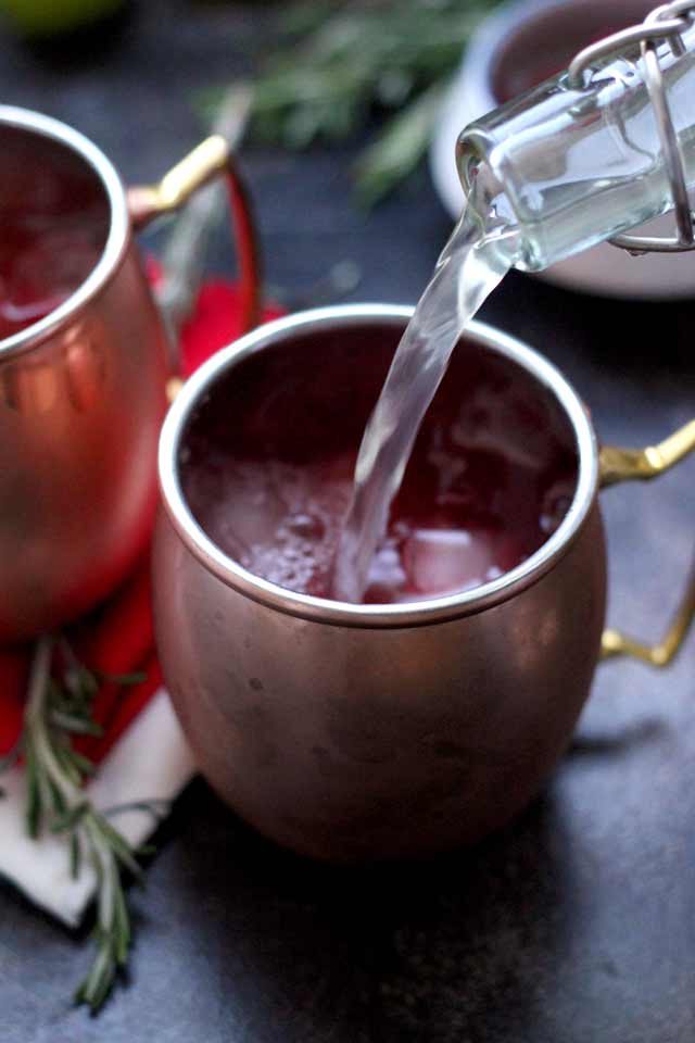 Cranberry Moscow Mule Being Poured in a Copper Mug.