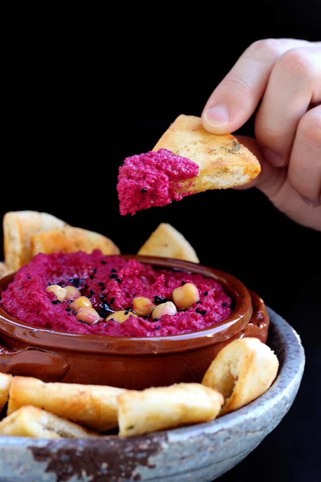 Holding a Pita Chip Dipped in Pink Hummus
