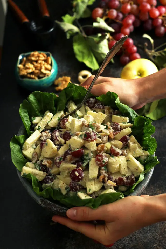 Healthy Vegan Waldorf Salad Recipe - Hands Holding a Bowl above the Table