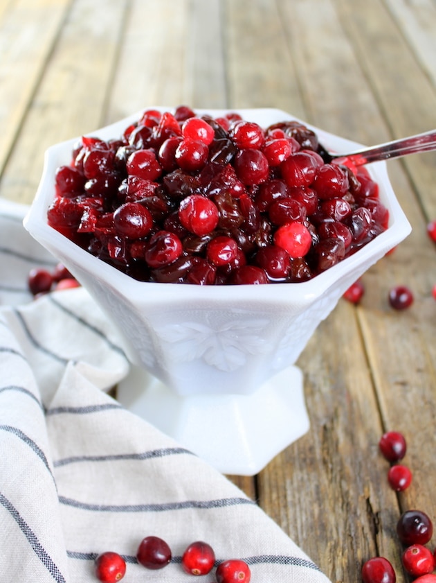 Cranberry and Dried Cherry Sauce in a white bowl with a spoon.