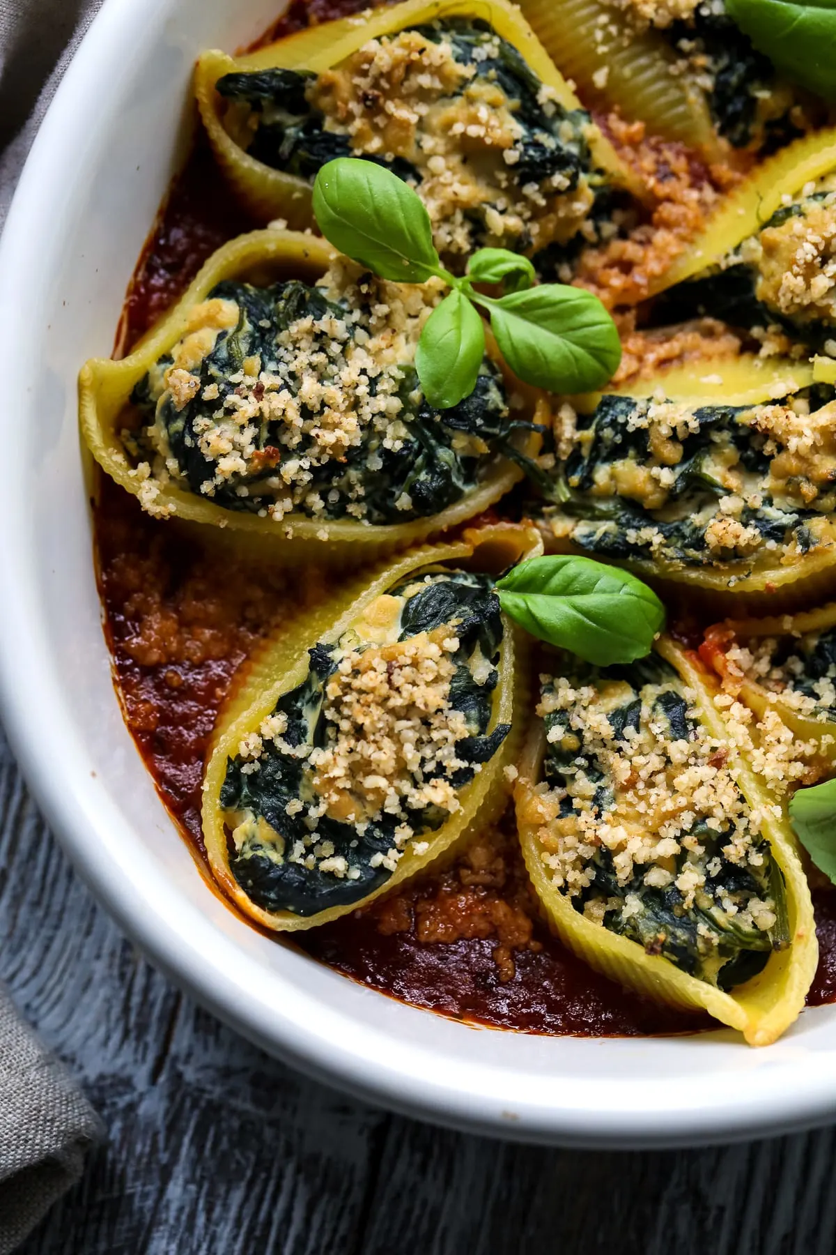 A closeup of vegan stuffed shells with tofu ricotta and spinach.