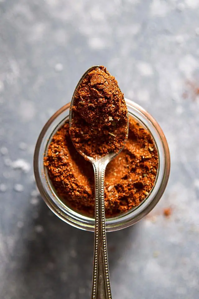 Spoonful of DIY taco seasoning on a jar shot from above