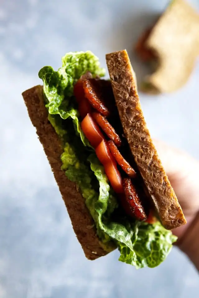 Hand Holding a Vegan BLT Sandwich