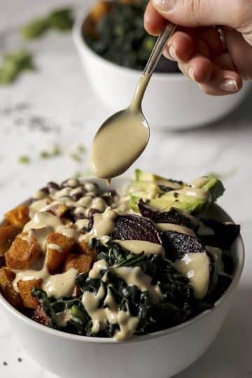 Pouring the sauce over vegan Buddha Bowls