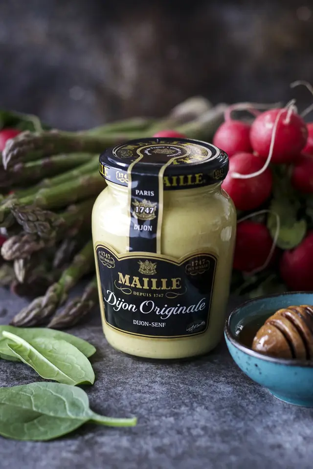 A Jar of Maille Dijon Mustard Surrounded by Spring Vegetables