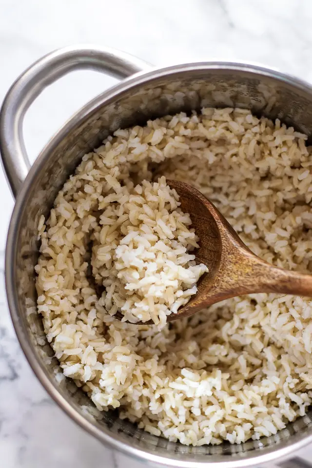 Cooked Brown Rice in a Pot with a Wooden Spoon
