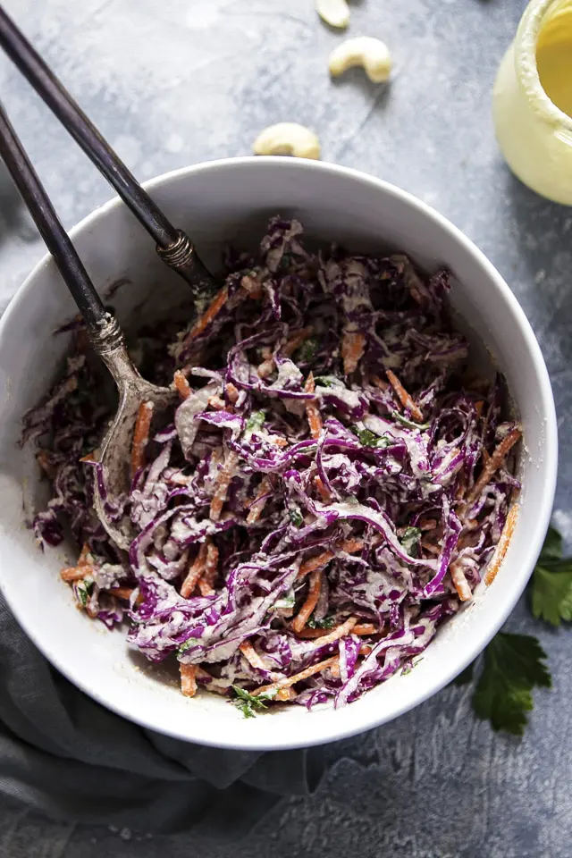 Purple Cabbage Slaw in a White Bowl with Utencils