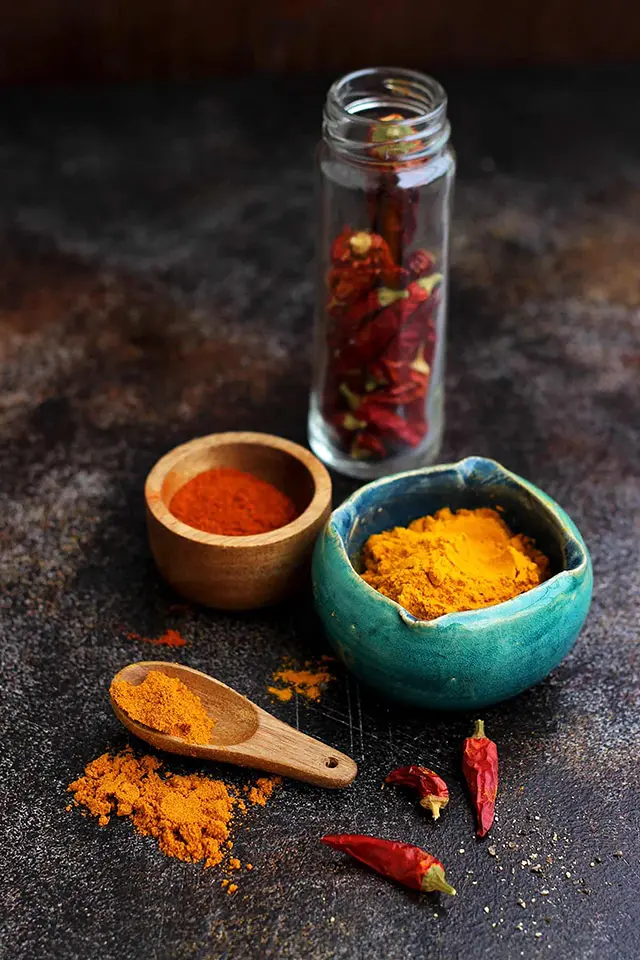 Spices in Bowls and Spoons on a Dark Background