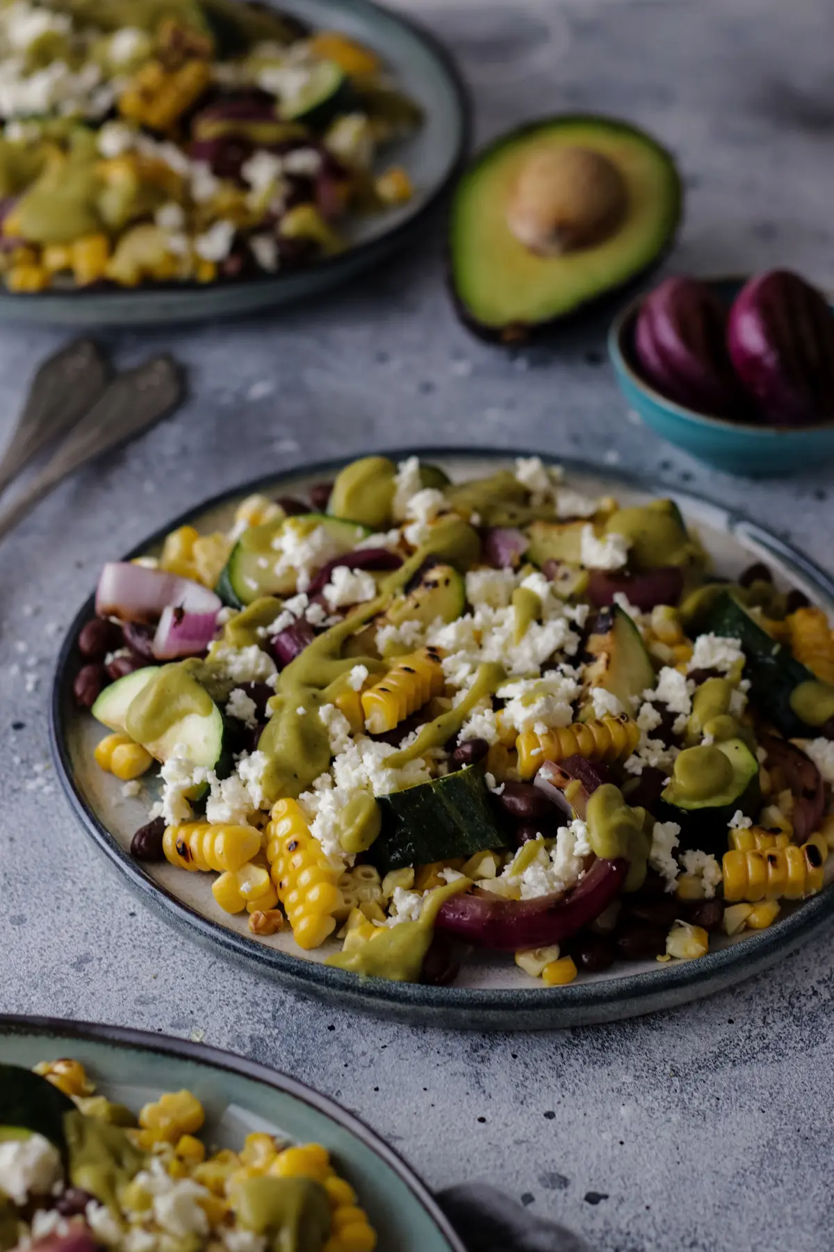 Corn Zucchini Salad on a Plate Surrounded by Ingredients