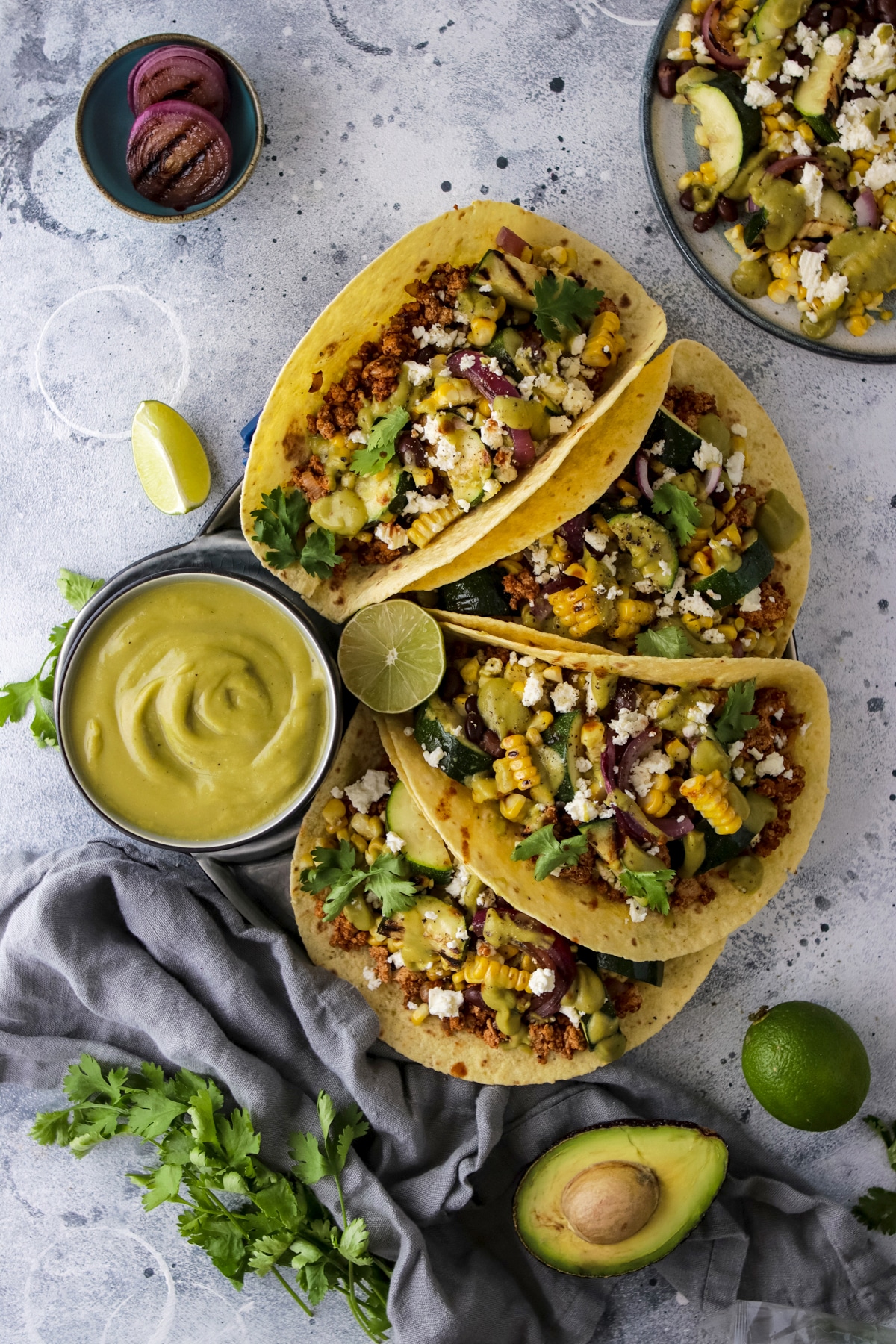 Zucchini corn tacos with avocado sauce in a large plate.