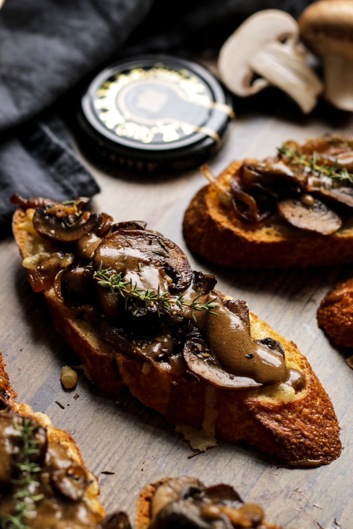A Closeup Shot of a Mushroom Crostini with Balsamic Mustard Sauce on a Wooden Background.
