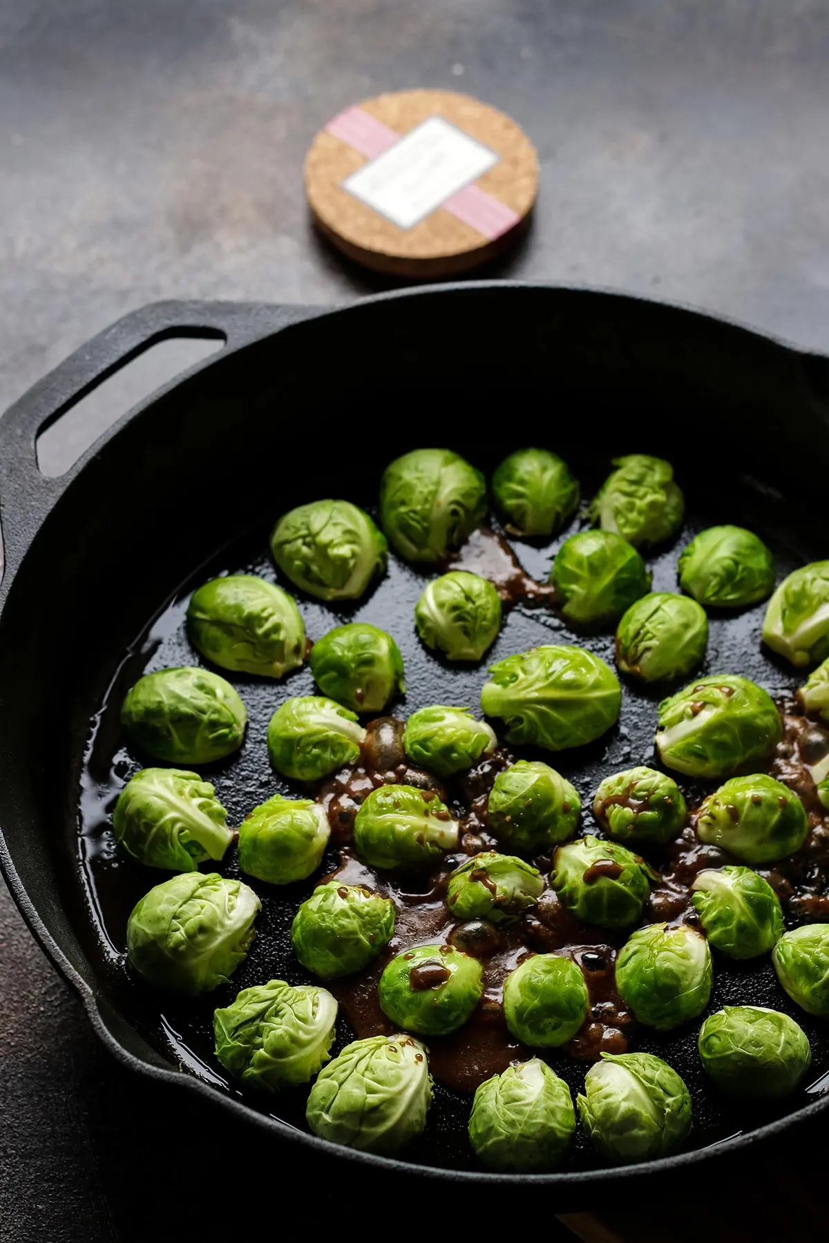 Adding Balsamic Glaze to Brussels Sprouts in a Skillet.