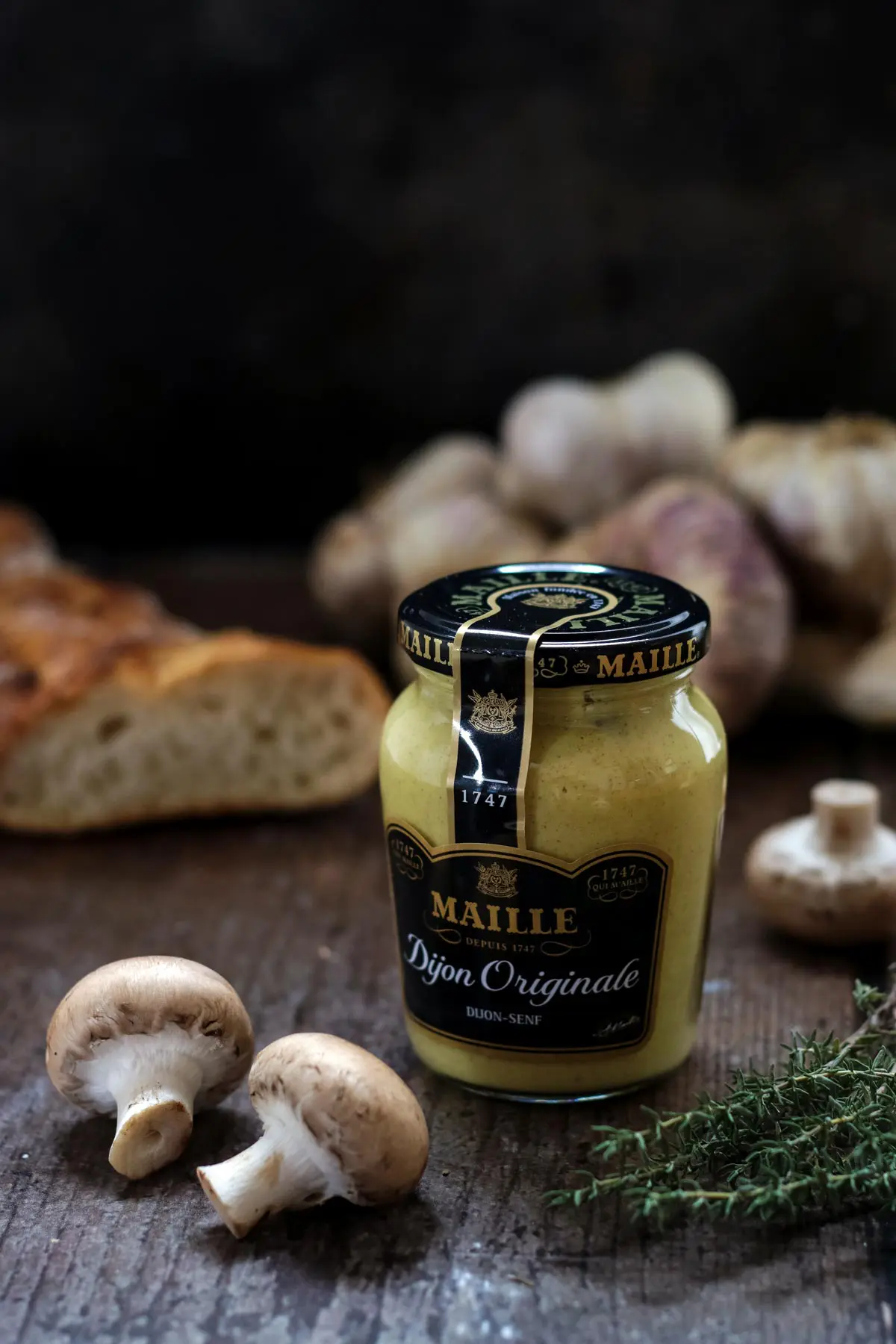 Maille Dijon Mustard Next to Mushrooms and Thyme.