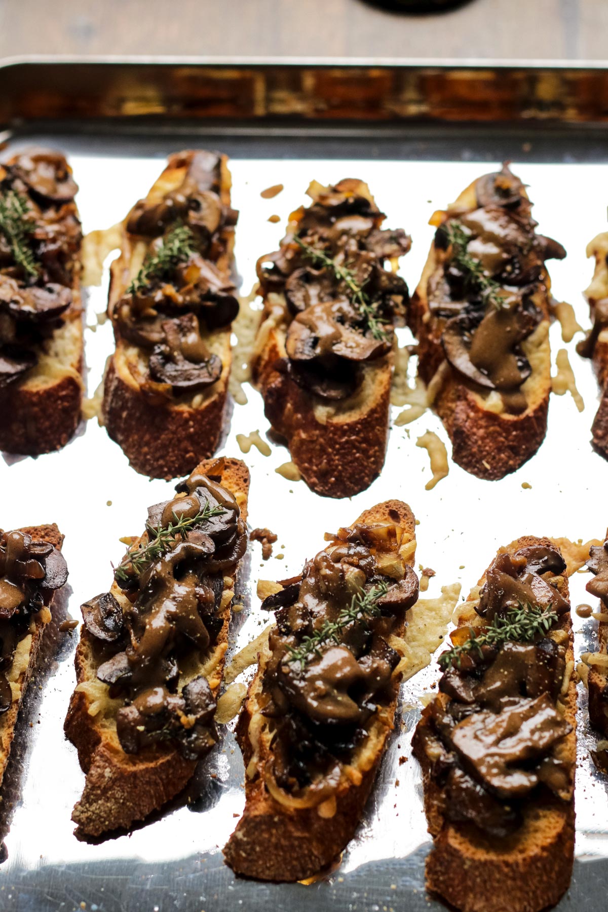Mushroom Crostini Drizzled with Balsamic Dijon Sauce and Garnished with Fresh Thyme.