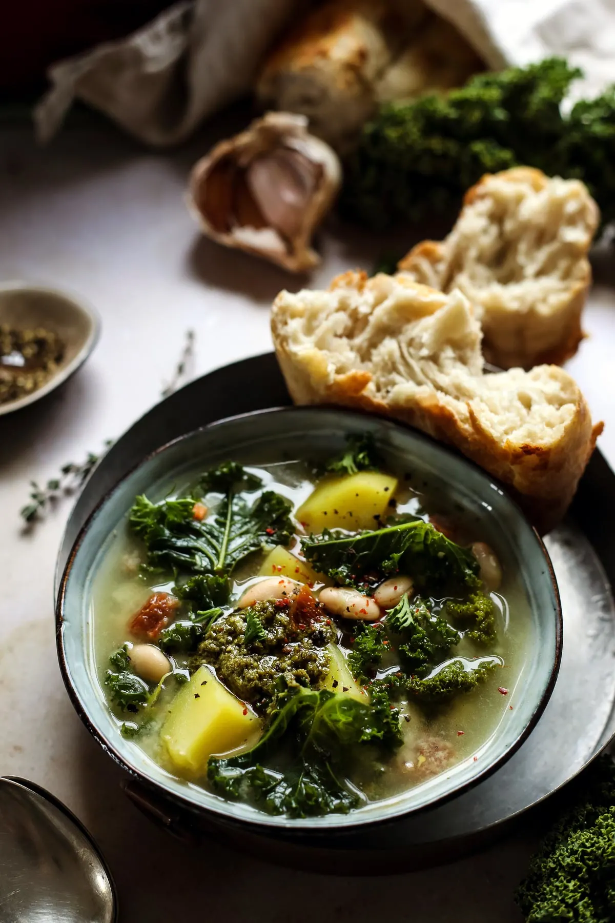 Potato and kale soup in a bowl served with crusty bread.