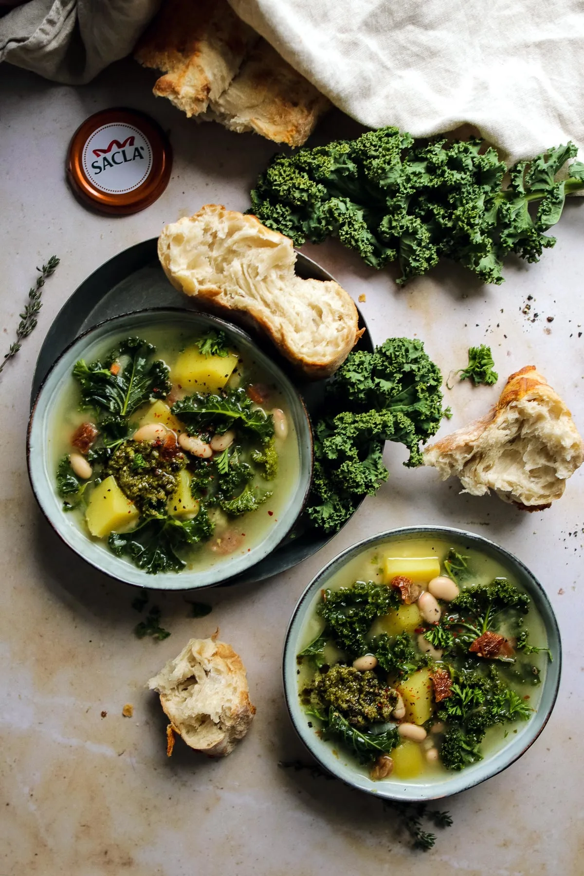 Two bowls with vegetarian Tuscan soup served with crusty ciabatta bread.