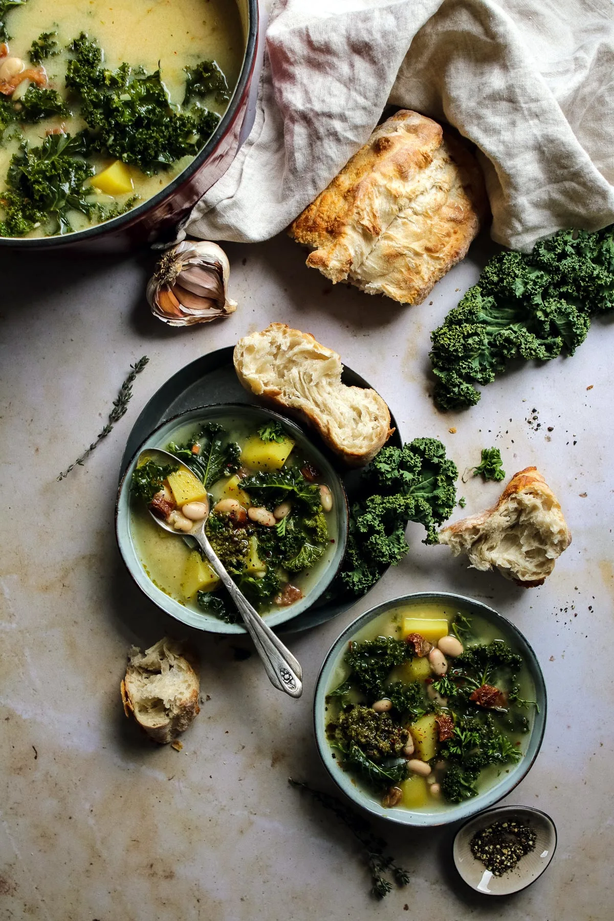 Vegan Zuppa Toscana in bowls with bread.