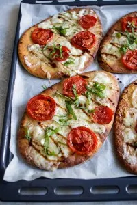 Baked naan pizza margherita on a baking tray