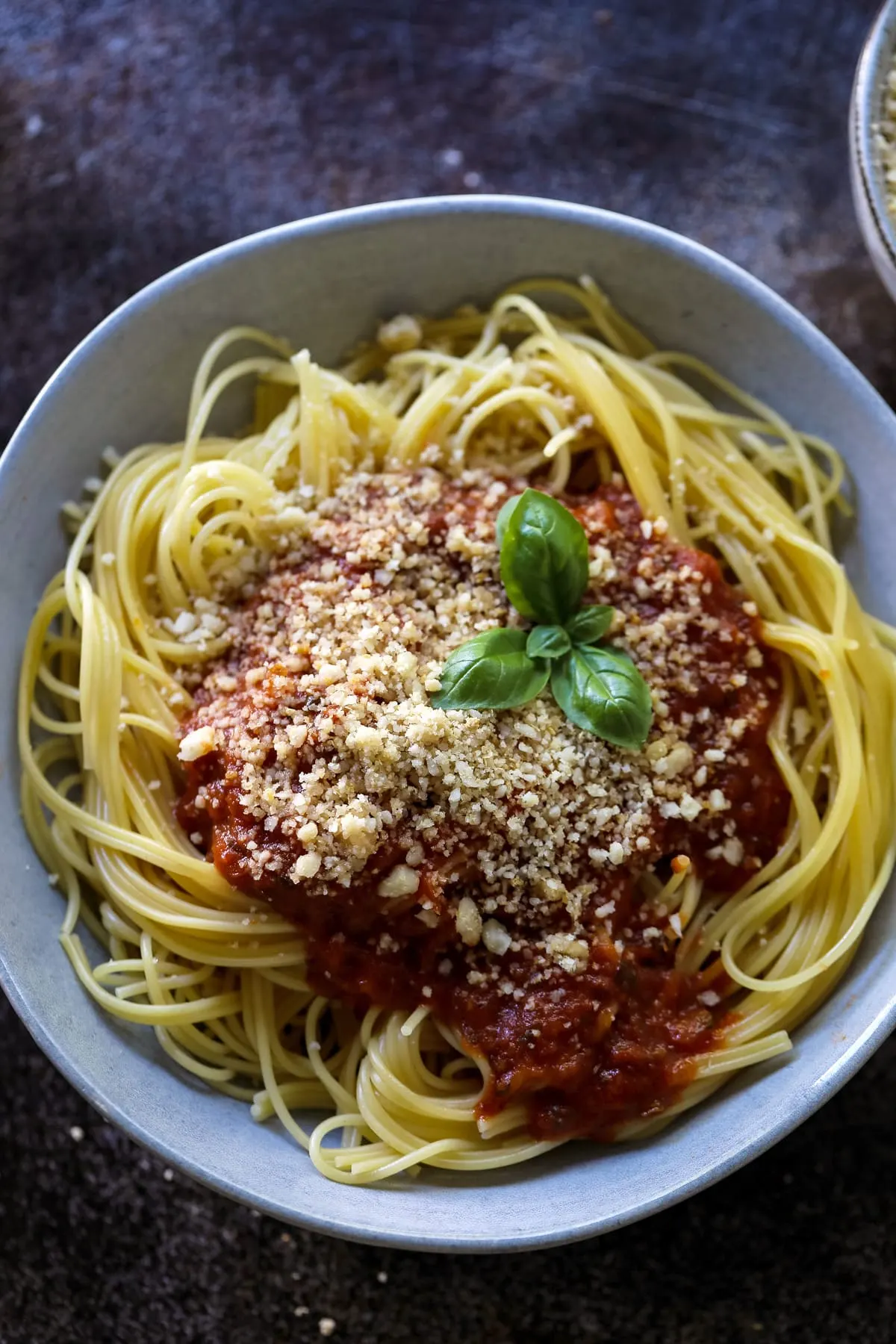 Spaghetti with Tomato Sauce Macadamia Parmesan and Basil on a Plate.
