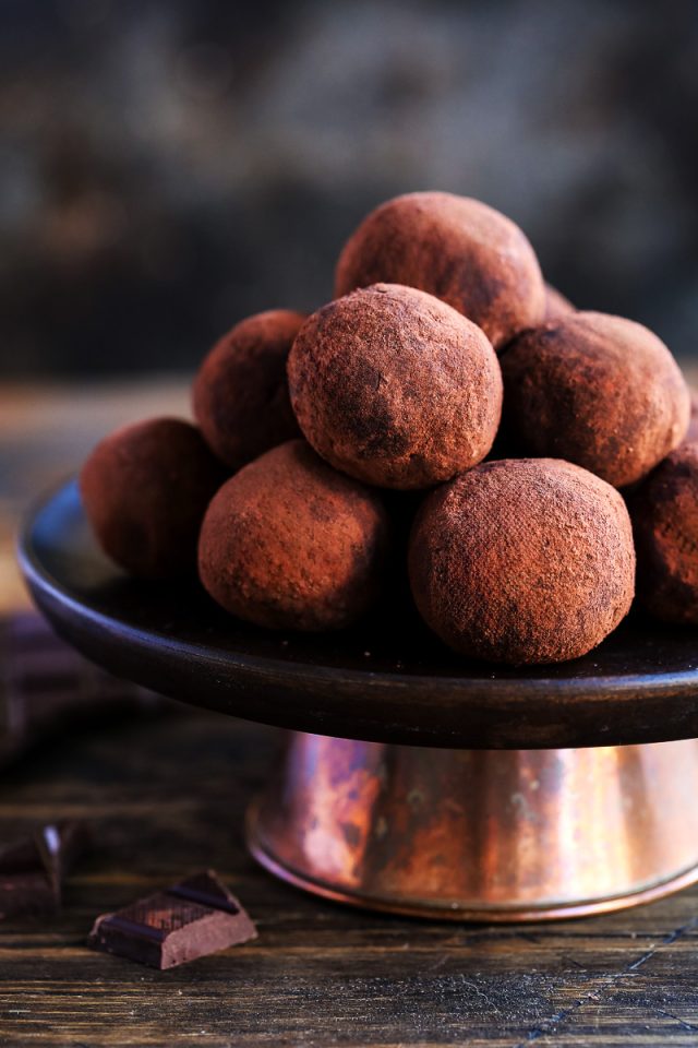 Chocolate truffles in a pile on a cake stand.